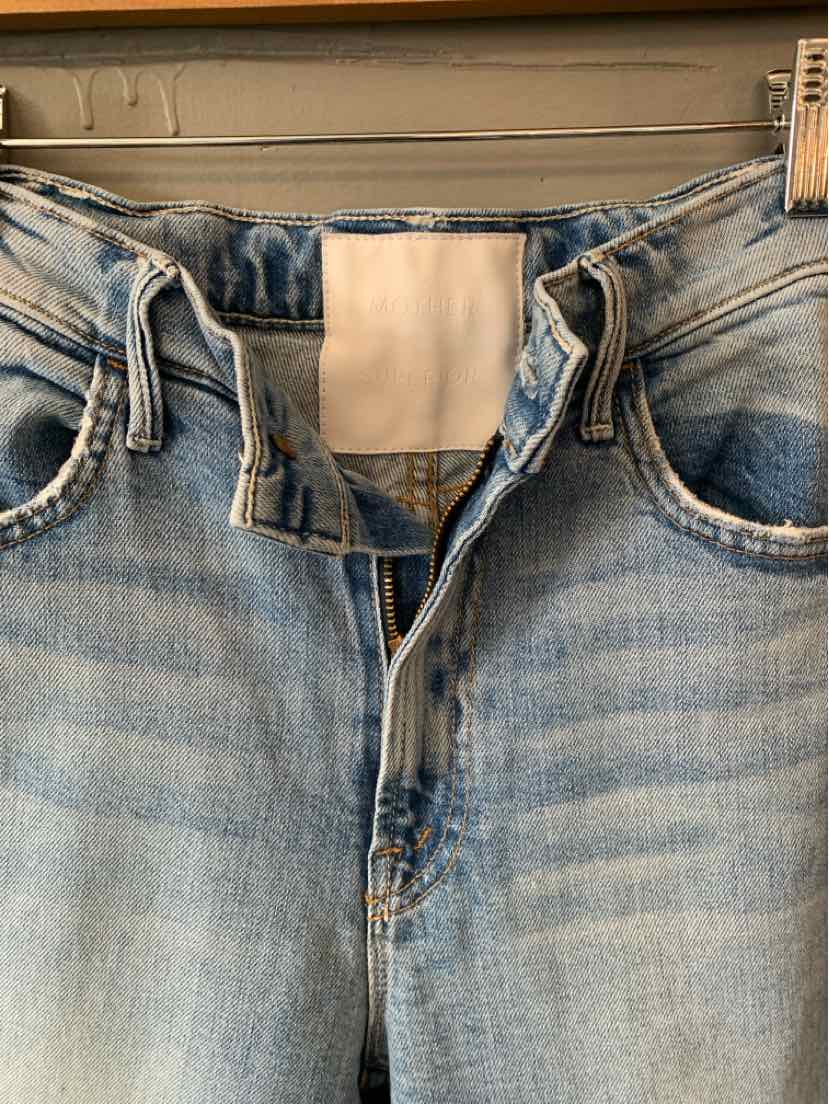 Light blue denim jeans with button fly and faded detailing on the front waistband and pockets.