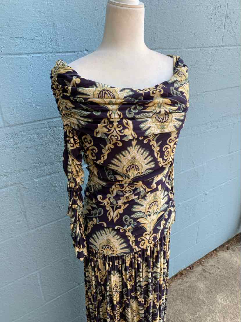 Long-sleeve dress with black background and intricate gold and beige floral baroque pattern, fitted bodice, and gathered.