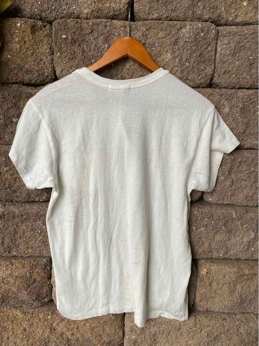 White short-sleeve cotton t-shirt with a relaxed fit hanging on a wooden hanger.