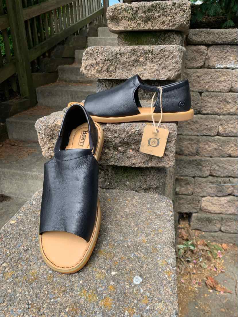 Black leather slip-on sandal with tan rubber sole and rounded toe, size 9.