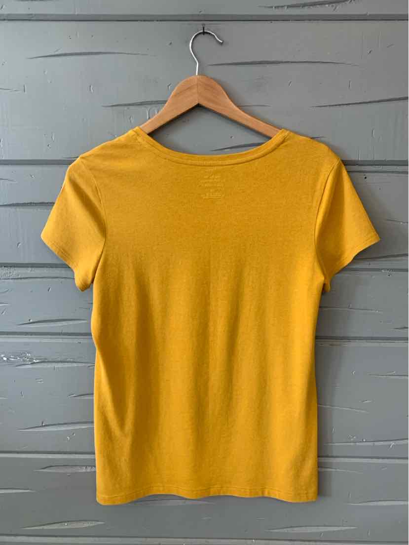Yellow short-sleeve crew neck knit top on wooden hanger against gray wall.