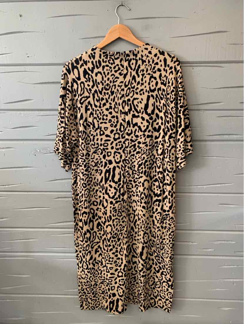 Tan knee-length dress with black leopard print and short ruffled sleeves on wooden hanger.