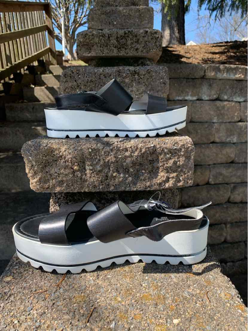 Black leather wedge sandals with wide front strap and jagged white sole, size 40.