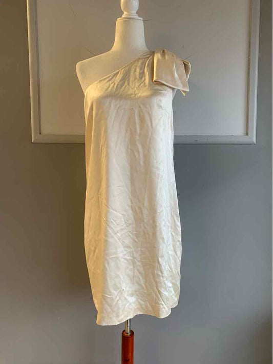 Ivory silk one-shoulder dress with a large ruffle detail on the shoulder, knee-length.