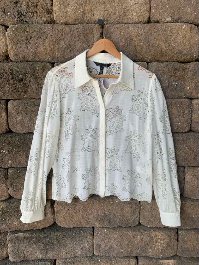 White long-sleeve lace blouse with collar and button-down front, scalloped hem detail.