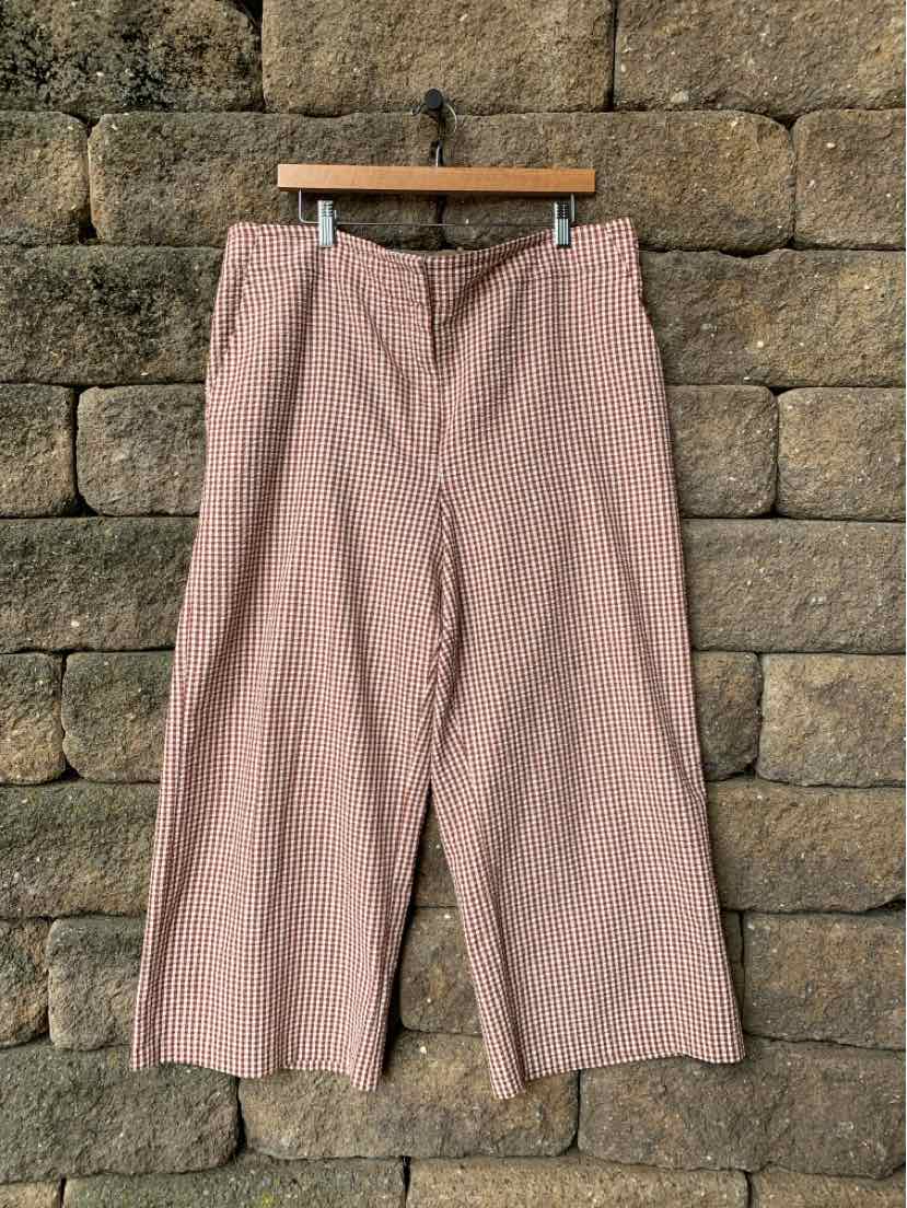 High-waist wide-leg pants in light pink gingham fabric with front zipper and pockets.