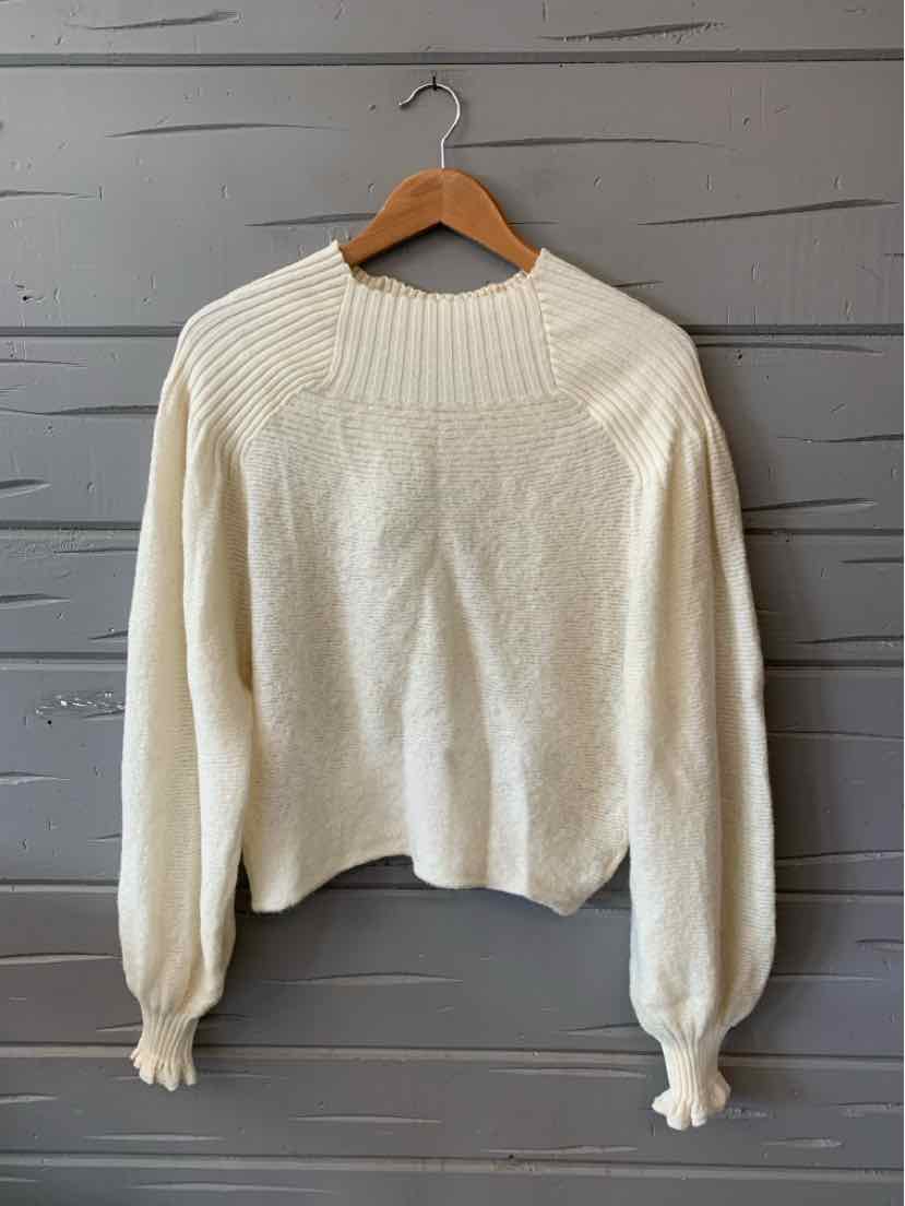 Cream-colored knit sweater with ribbed yoke and cuffs, slightly cropped fit.
