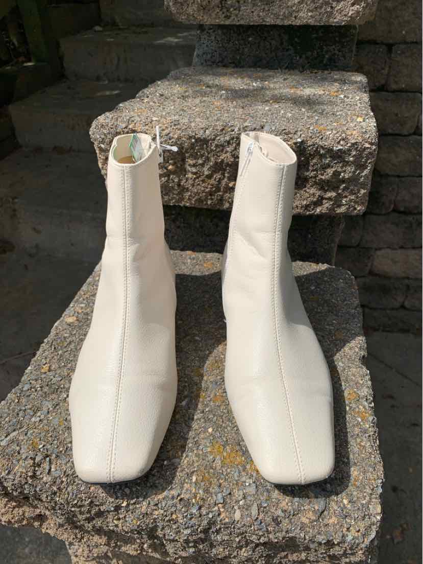 Pair of women's white leather ankle boots with square toes and side zippers, size 6.5.