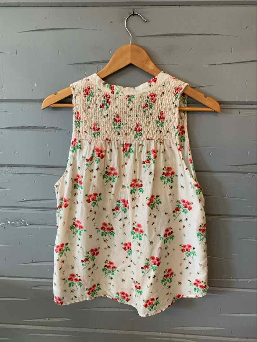 White sleeveless blouse with red and green floral print and smocked yoke, loose fit large size.
