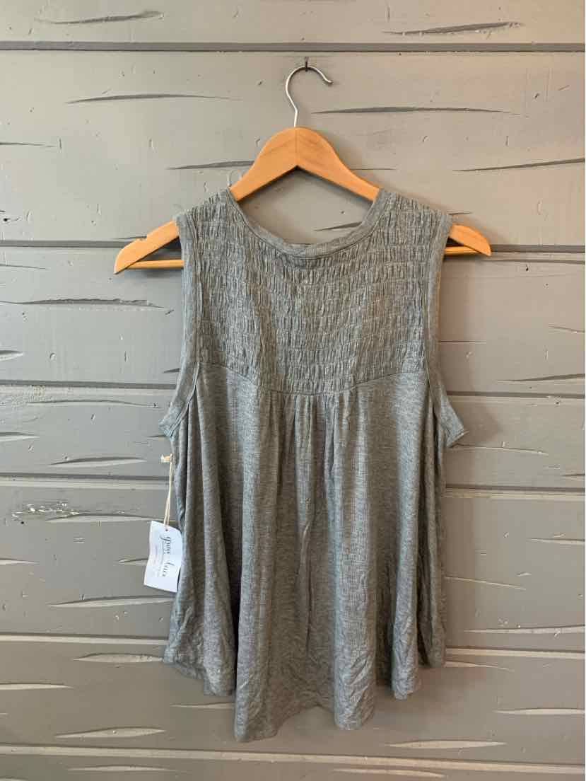 Light gray sleeveless knit top with lace detailing on front yoke, loose fit, hanging on wooden hanger.