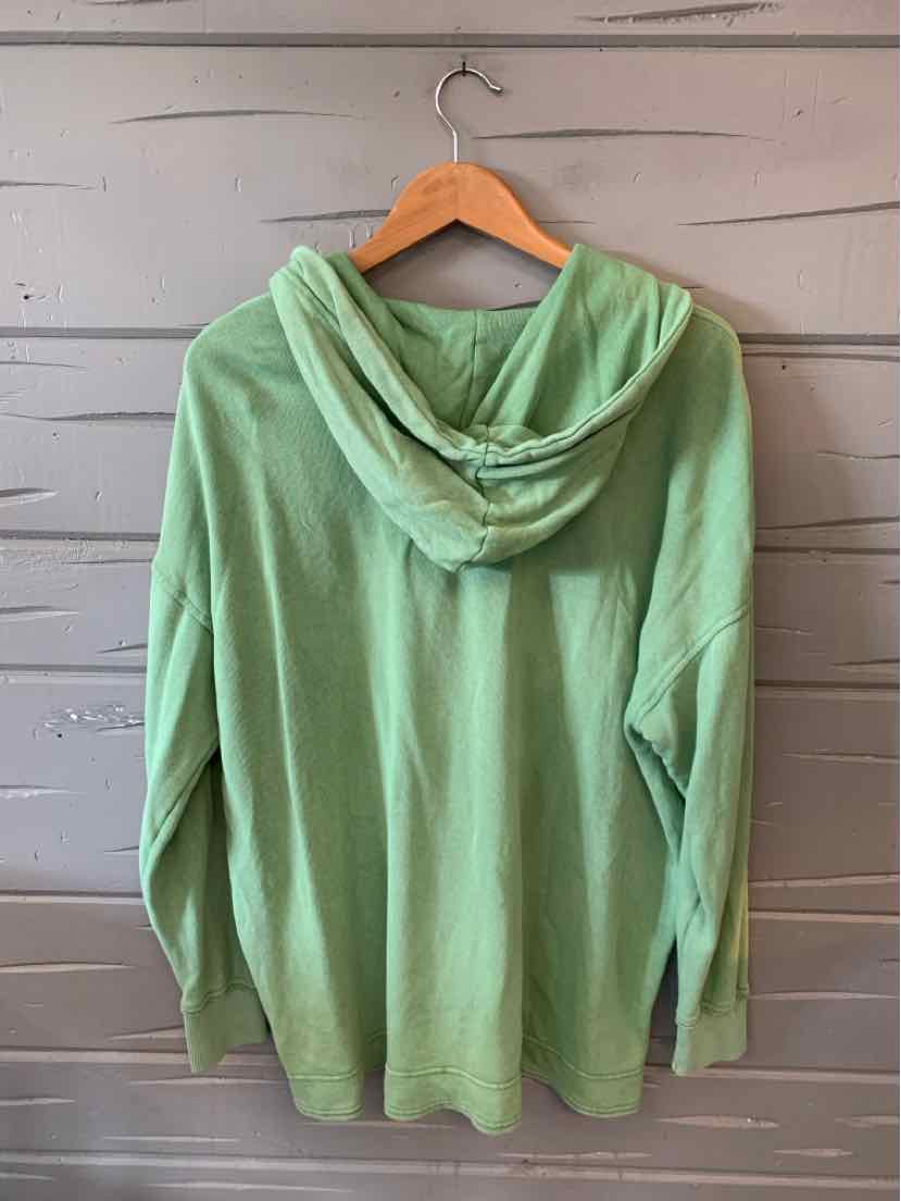 Light green long-sleeve hoodie with relaxed fit and hood, displayed on wooden hanger.