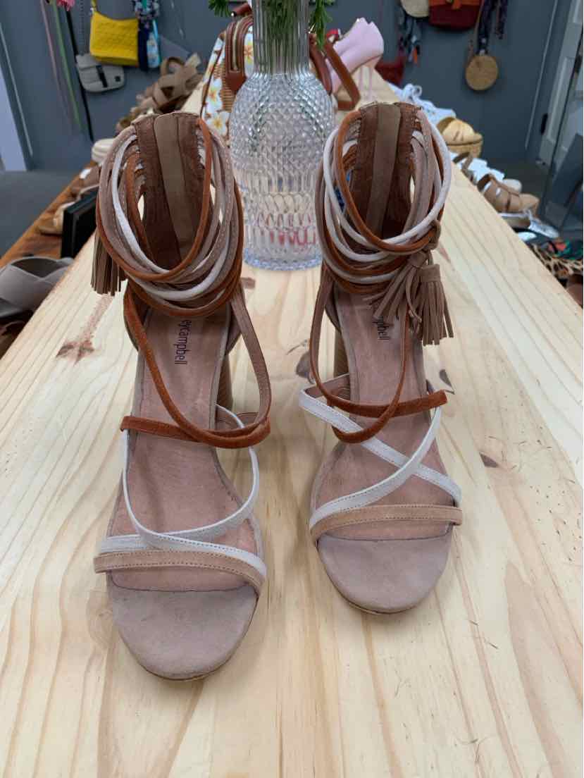 Tan suede open-toe high heel sandals with ankle wrap straps and fringe detailing.
