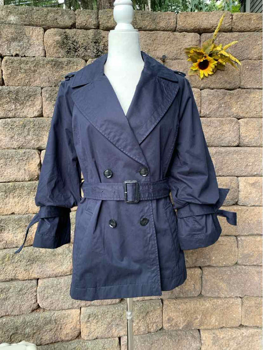 Navy double-breasted trench coat with wide lapels, belted waist, and cuff straps on mannequin.