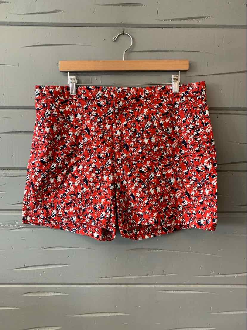 Red floral patterned women's shorts with a tailored fit, size 14, hanging on wooden hanger.