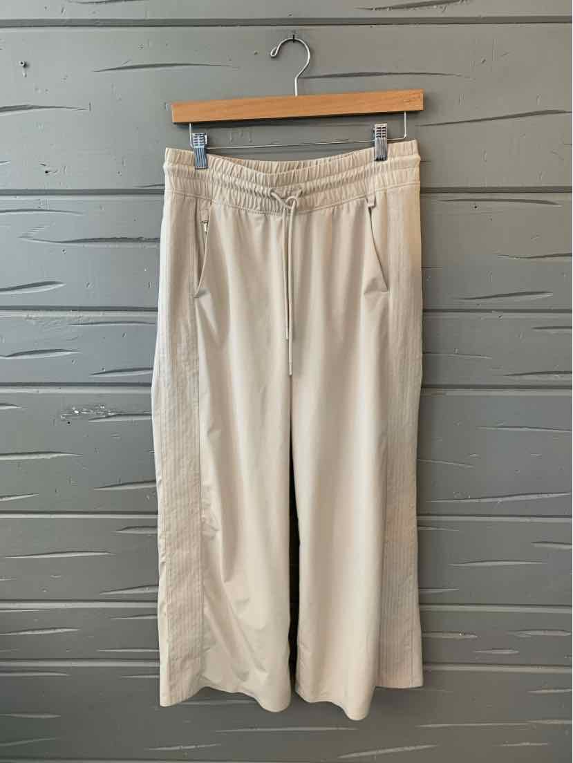 Beige wide-leg pants with drawstring waist and front pockets, size 6, soft fabric.