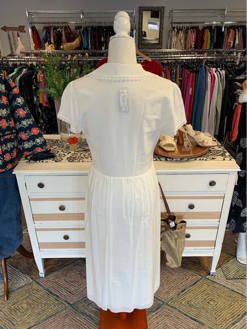 White short-sleeve midi dress with gathered waist and button details on back.