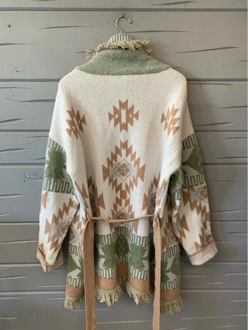 Cream knit cardigan with rust geometric motifs, sage green fringe, and a matching waist tie.
