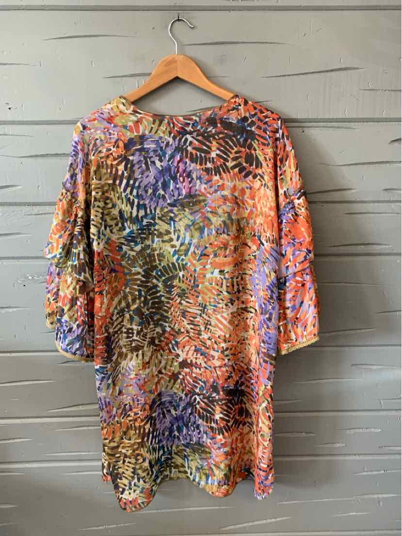 Colorful patterned long-sleeve blouse with orange, purple, and black abstract print on lightweight fabric.