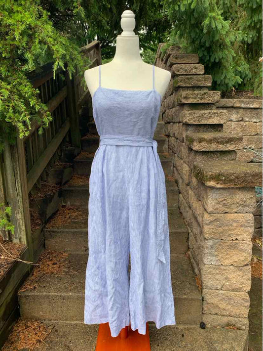 Light blue sleeveless midi dress with thin straps and fitted waist on a mannequin outdoors.