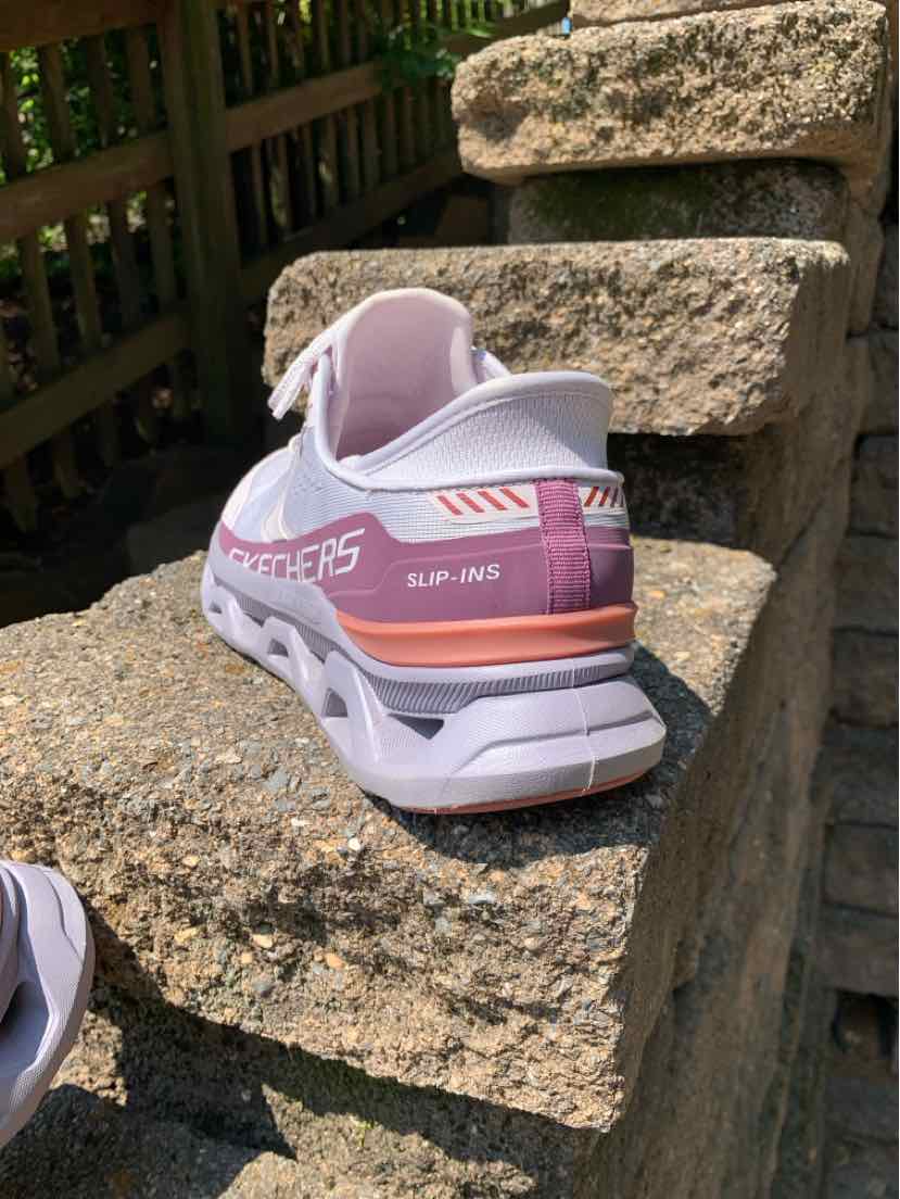 Light pink Skechers sneaker with white sole and orange accent on heel, size 9.5 Women's.