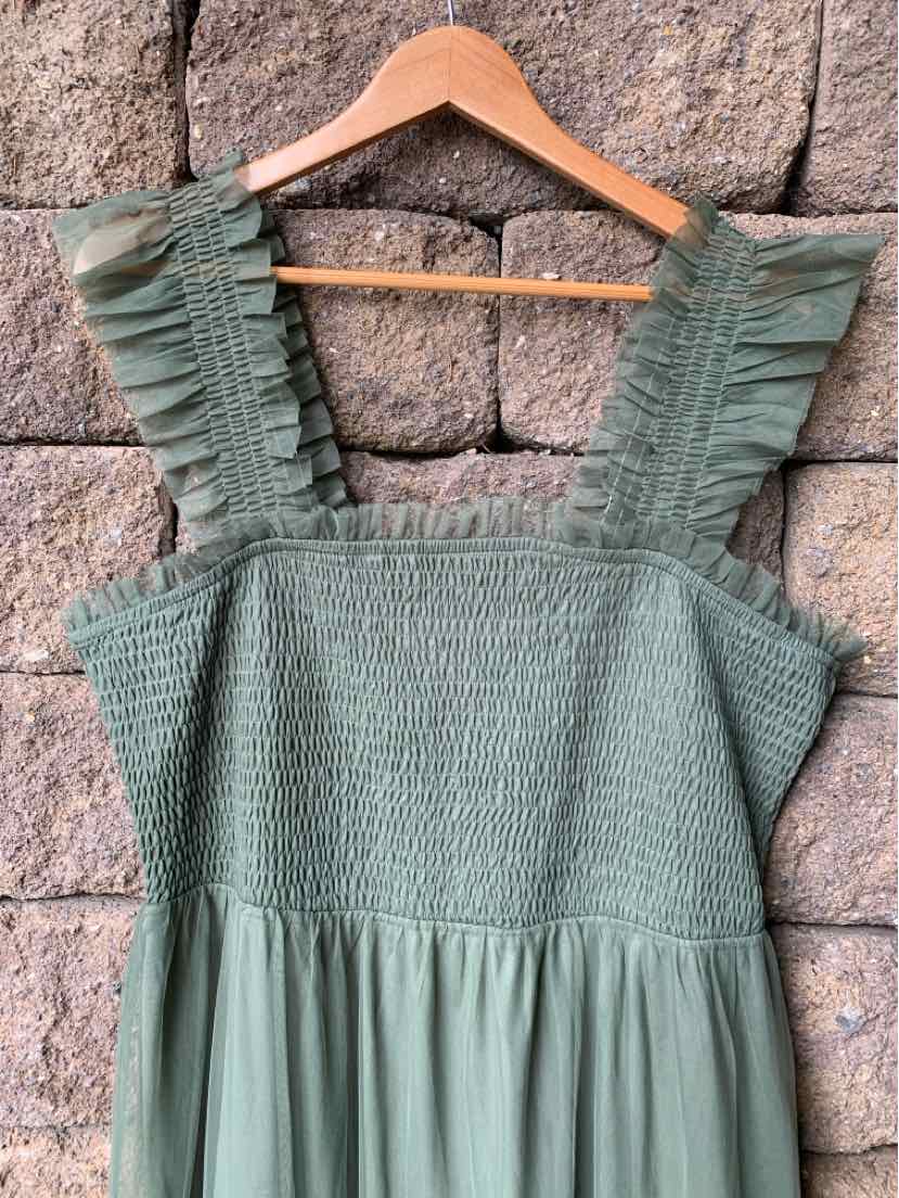 Green sleeveless dress with smocked bodice and ruffled shoulder straps.