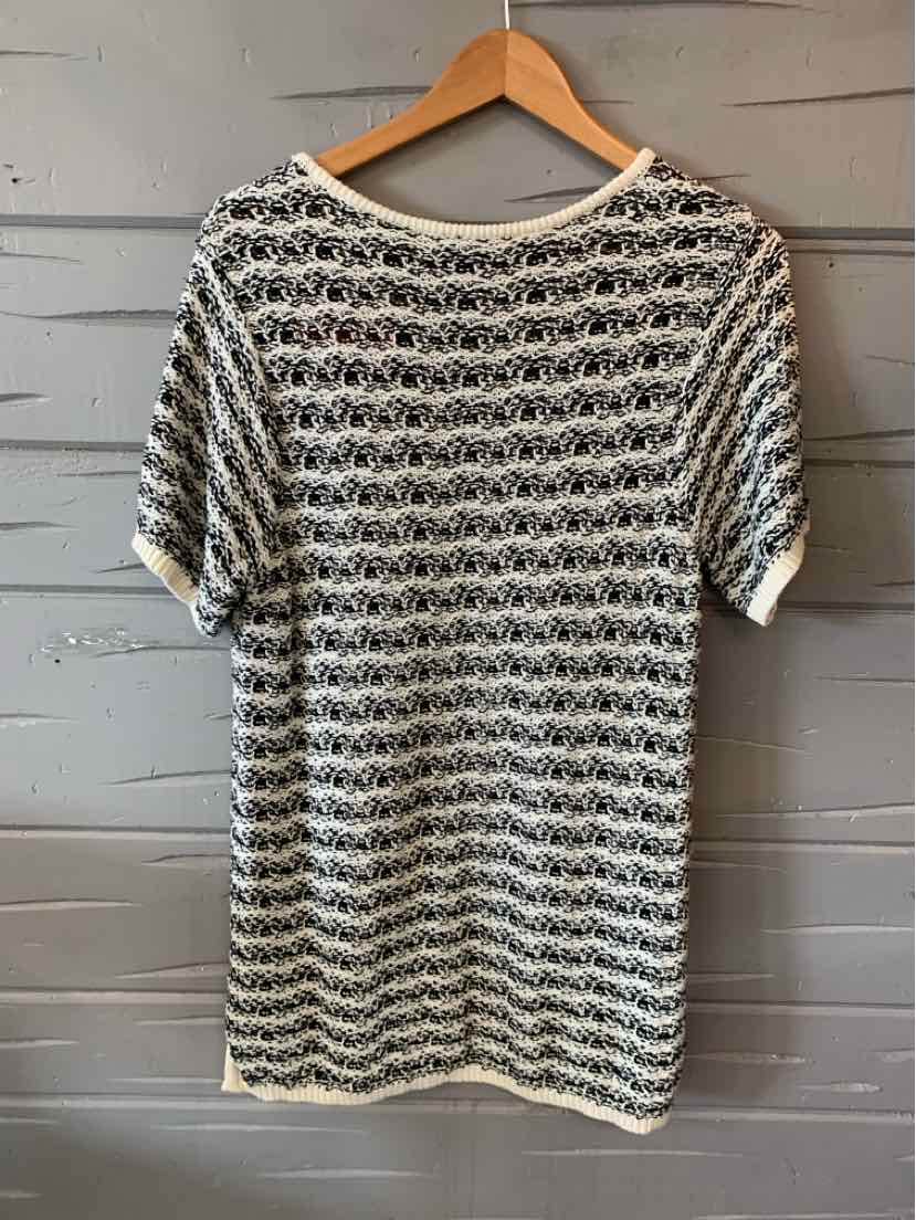 Black and white striped short-sleeve knit top with a relaxed fit hanging on wooden hanger.