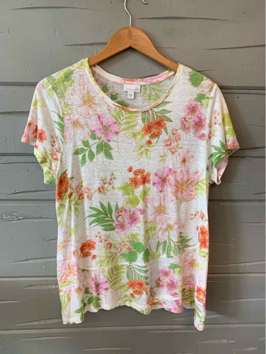 White short-sleeve floral t-shirt with pink, orange, and green flowers on a wooden hanger.