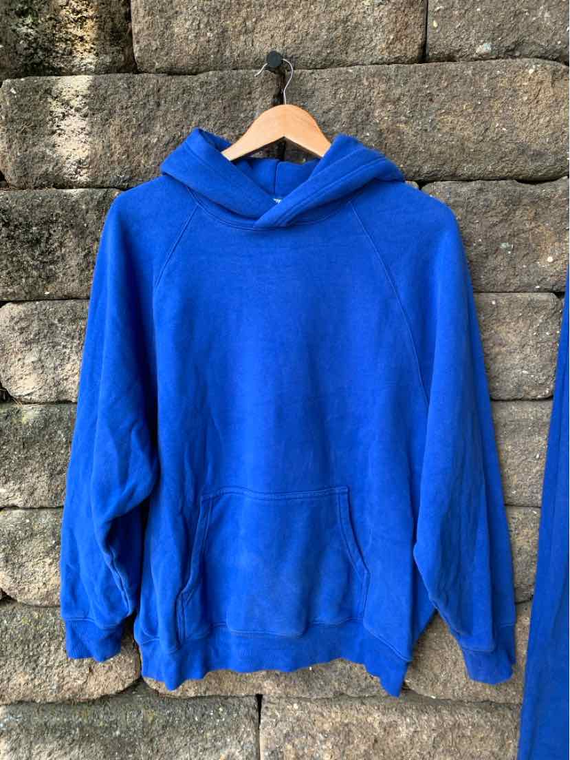 Bright blue oversized hoodie with front kangaroo pocket and dropped shoulder seams.