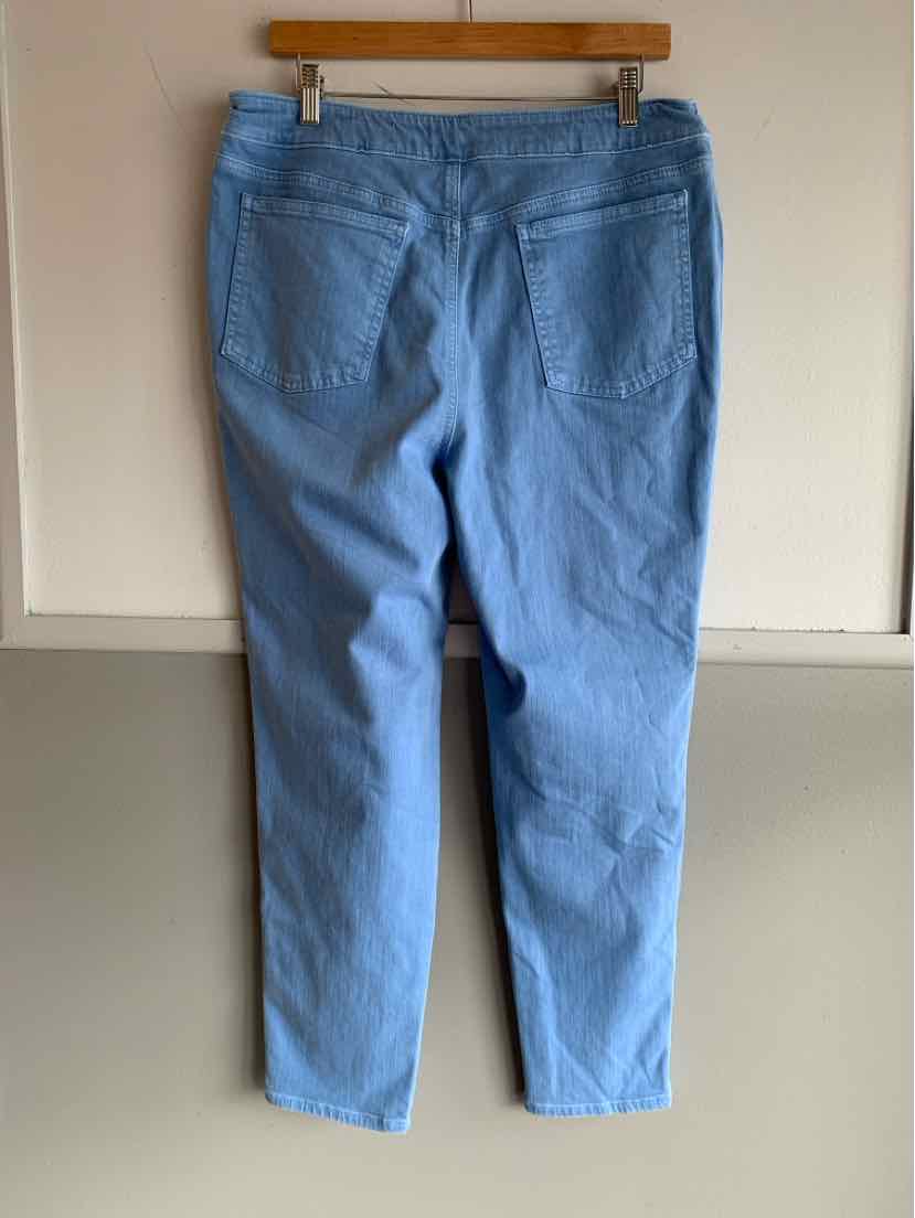 Light blue straight-leg pants with back patch pockets hanging on wooden hanger against white wall.