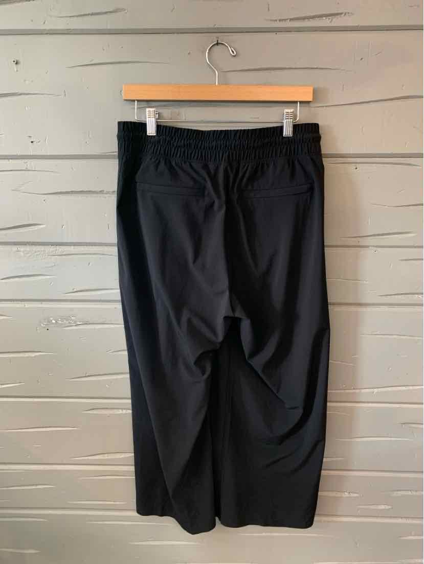Black wide-leg cropped pants with elastic waistband, smooth fabric, size medium.