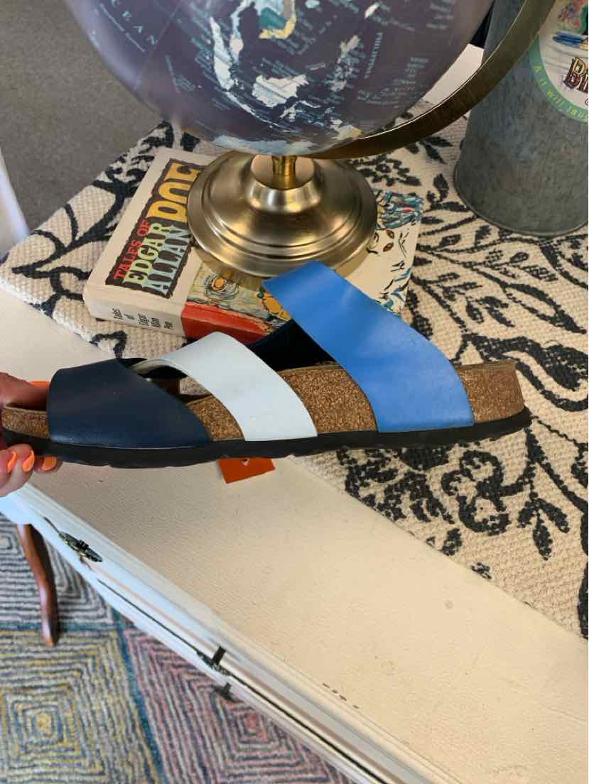 W Birkenstock multi-color sandal with blue, white, and dark straps on cork footbed.