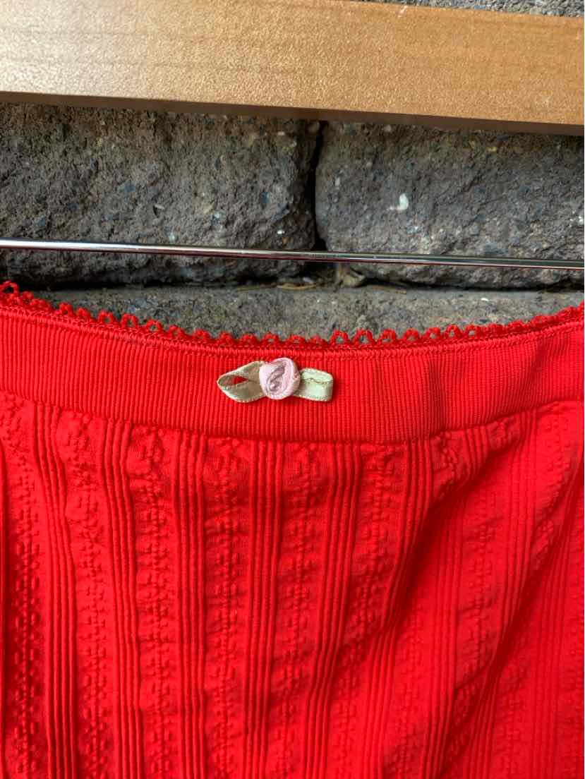 Red ribbed knit lingerie top with scalloped trim and small white bow detail at neckline.