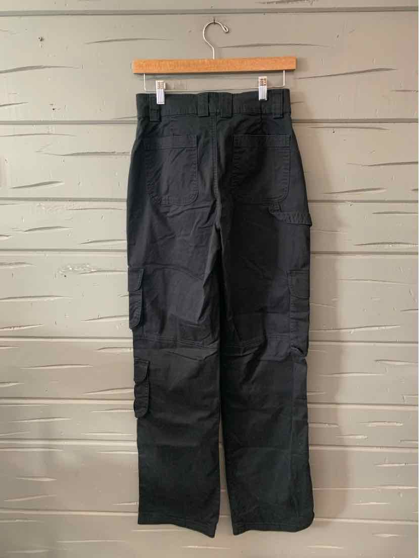 Black high-waisted straight-leg pants with belt loops and front pockets hanging on wooden hanger.