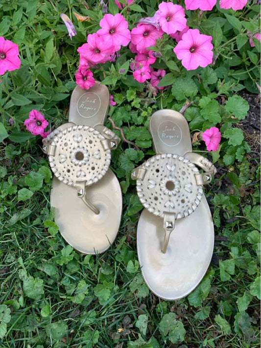 Metallic gold flat sandals with circular beaded medallion and thong strap design, size 6.
