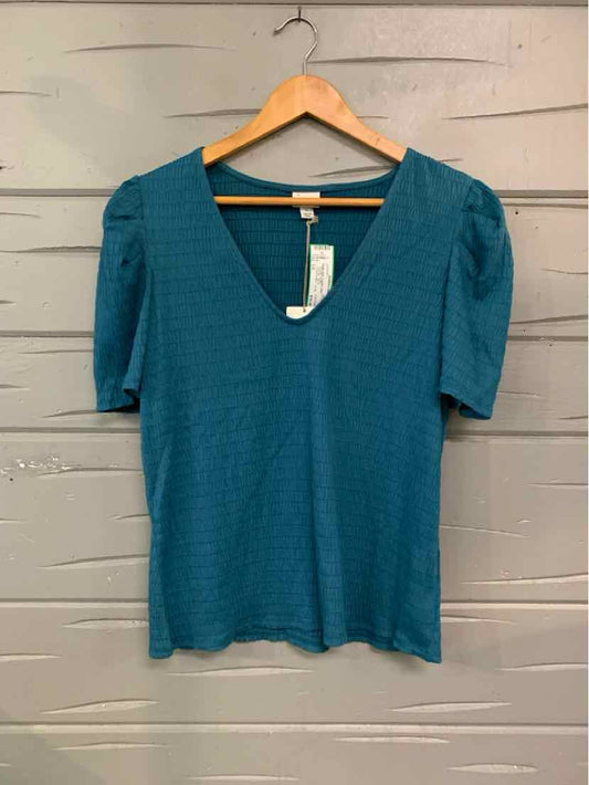 Teal short-sleeve knit top with V-neck and subtle texture, hanging on wooden hanger.