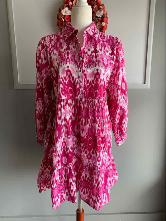 Pink patterned long-sleeve dress with gathered waist and collar on mannequin.