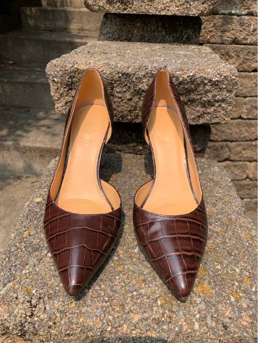 Brown pointed-toe pumps with croc-embossed leather and a sleek heel design.