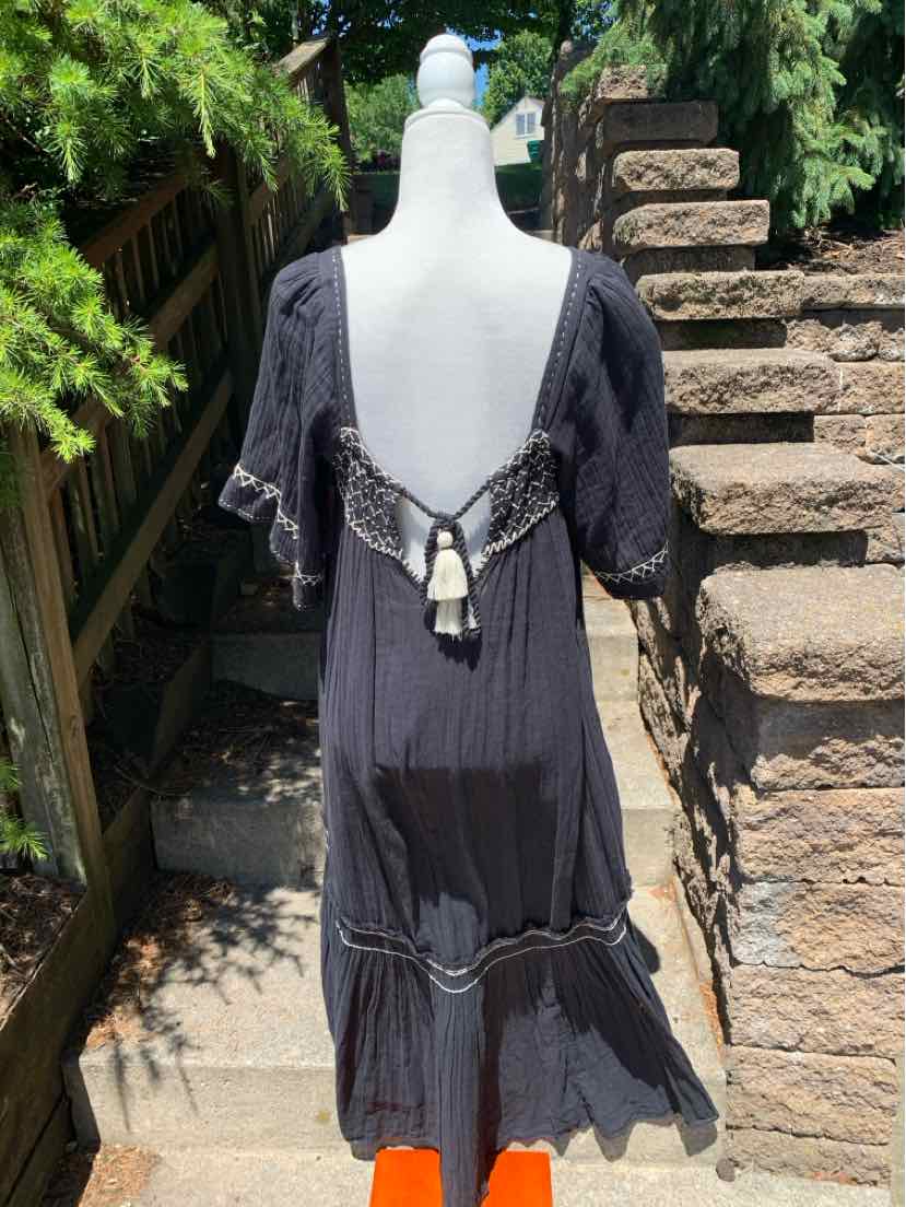Black bohemian maxi dress with short puff sleeves, deep V back, and tassel tie closure.