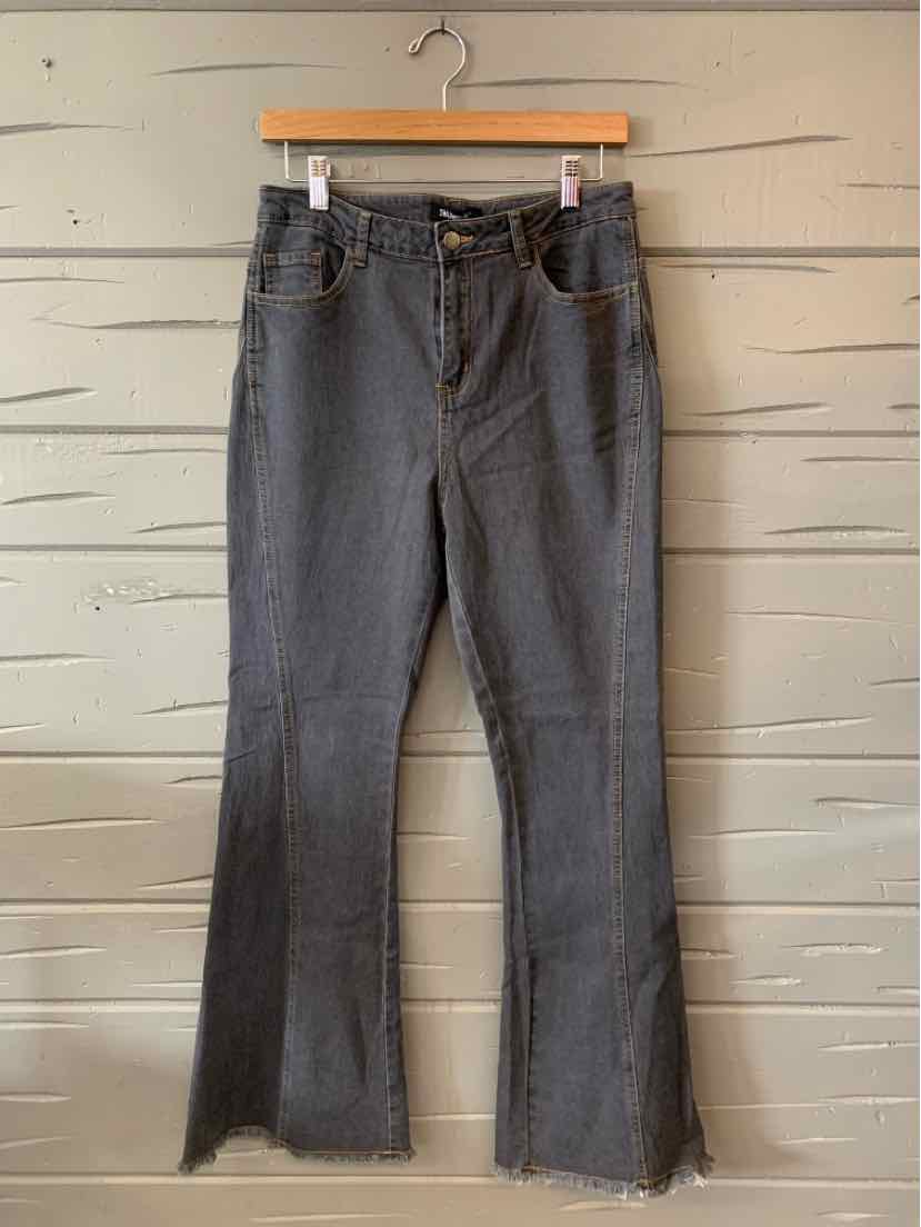 Gray medium-wash denim jeans with a mid-rise waist and slight flare hem, hanging on a wooden hanger.