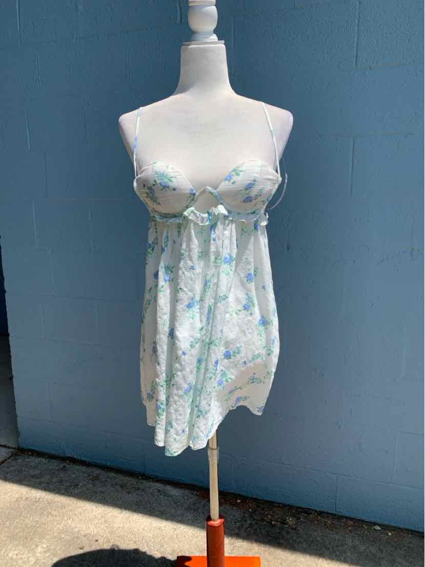 White floral spaghetti strap sundress with blue and green flower pattern and empire waist.