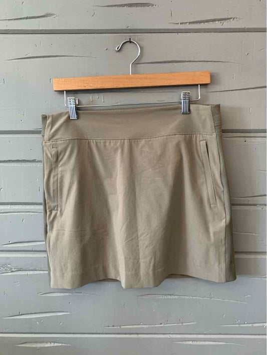 Taupe knee-length skort with front zipper pockets and a wide waistband on a wooden hanger.
