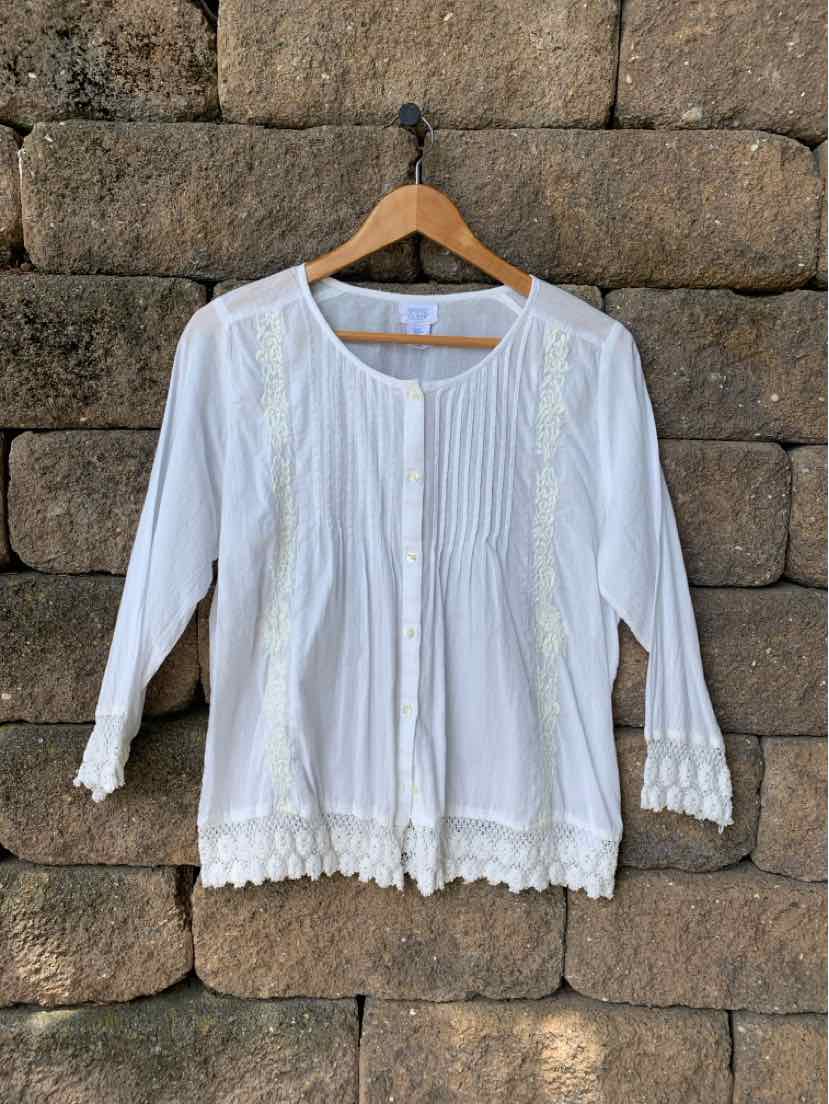 White long-sleeve blouse with pintuck detailing and delicate floral embroidery, scalloped hem.