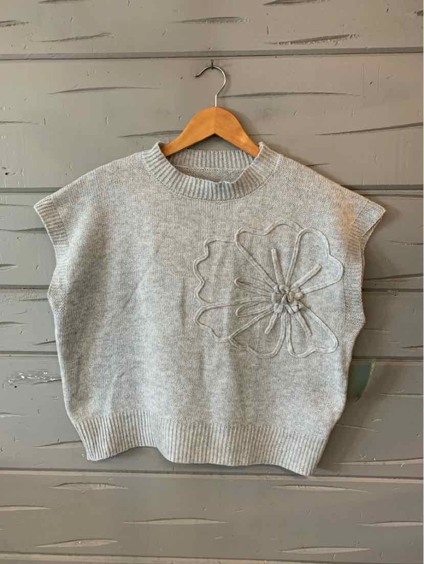Light gray knit short-sleeve sweater with round neck and floral knit applique on front.