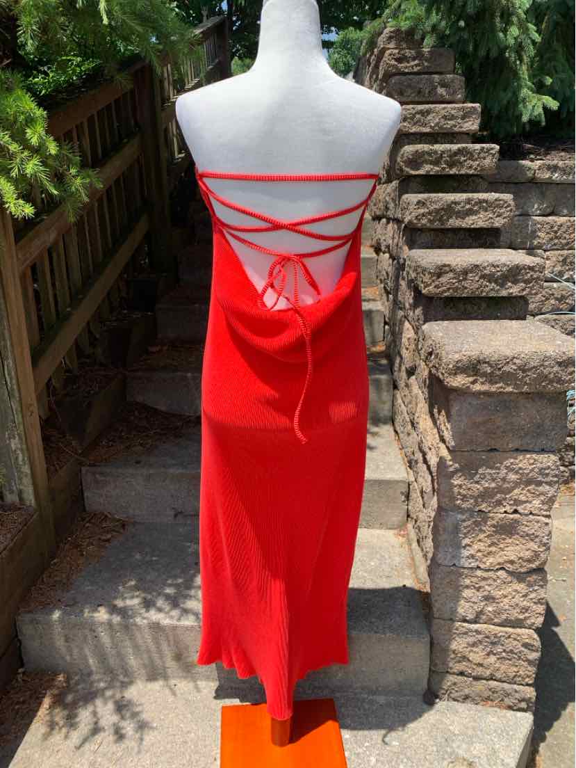 Red satin slip dress with open back and crisscross strap detailing, midi length.