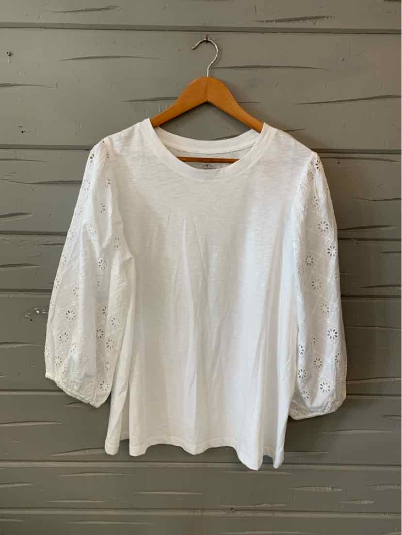 White blouse with round neckline and sheer puff sleeves embroidered with floral patterns.