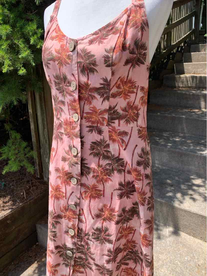 Pink sleeveless midi dress with tropical palm tree print and front button closure.