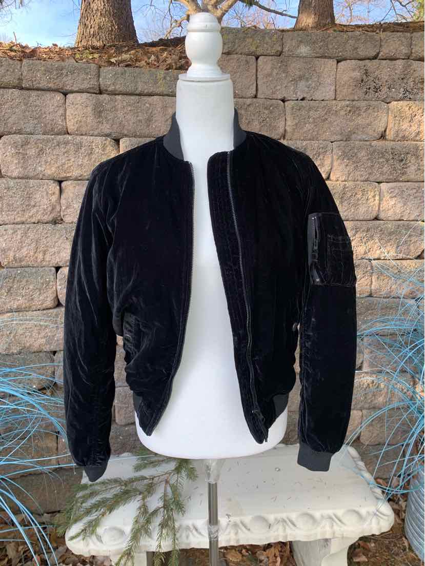 Black velvet bomber jacket with zip front and ribbed cuffs on mannequin.