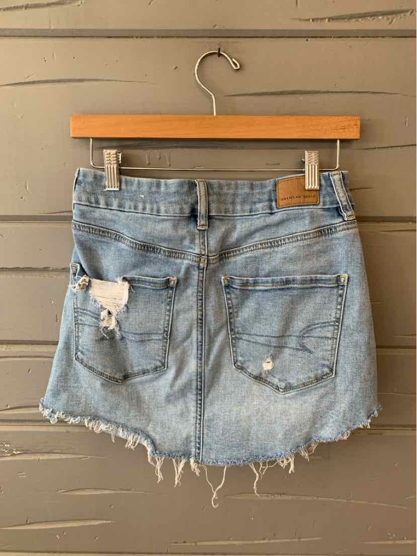 Light blue denim mini skirt with distressed details, frayed hem, and back pockets.