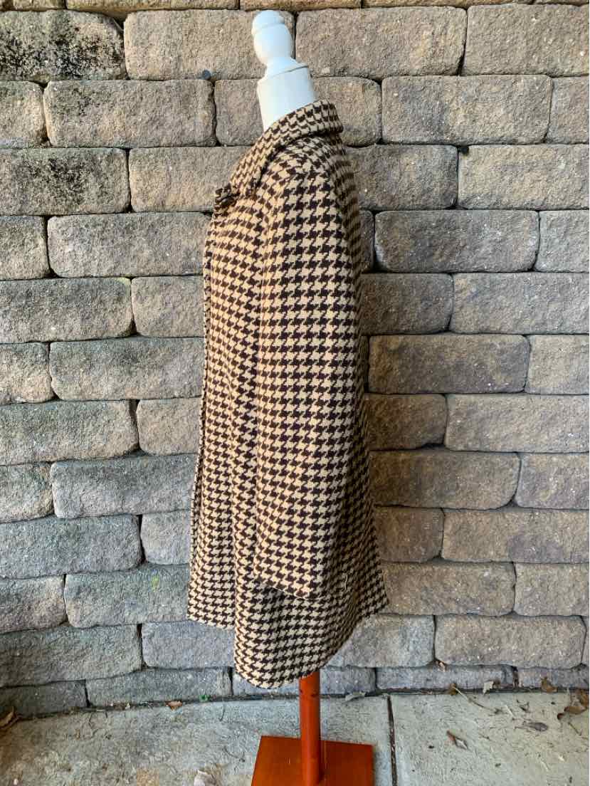 Women’s brown and black houndstooth coat with a long, straight silhouette and textured fabric.