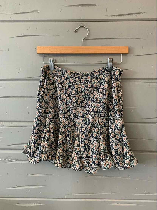 Black floral mini skirt with small white and peach flower prints, pleated design.